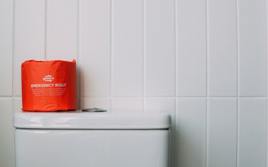 Red Toilet Paper on White Ceramic Toilet