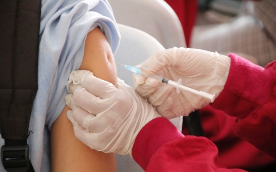 A student is being injected with a vaccine