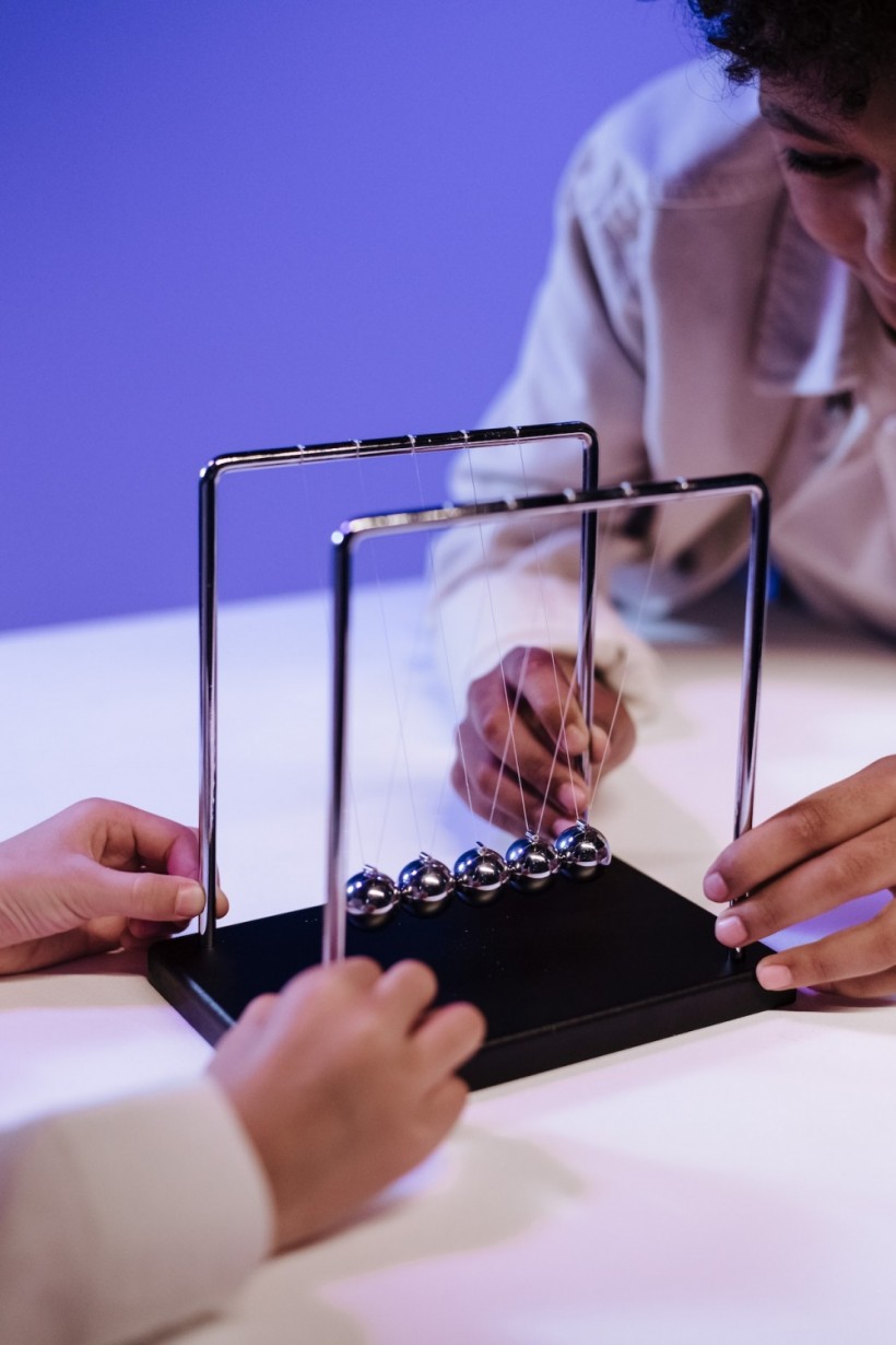 Children playing with newton's cradle