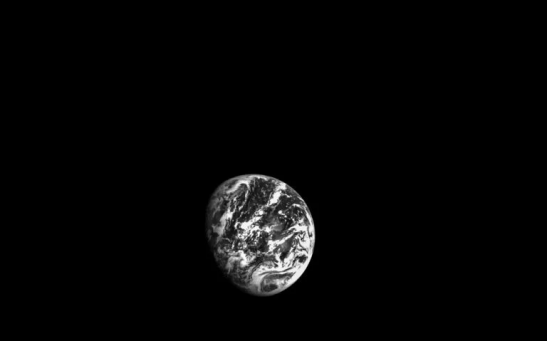 A black-and-white image of Earth captured by Orion’s optical navigation camera. 