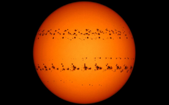 A time-lapse image of two major sunspot groups moving across the surface of the sun between Dec. 2 and Dec. 27, 2022, captured by Şenol Şanlı.