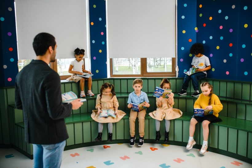 Man Reading In Front of Children
