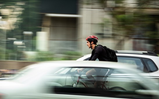 man riding bicycle near car