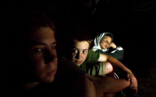 Students sit by the fire while camping out at the Center for Attention and Related Disorders (C.A.R.D.) camp at the Great Hollow Wilderness School July 30, 2003 in New Fairfield, Connecticut.